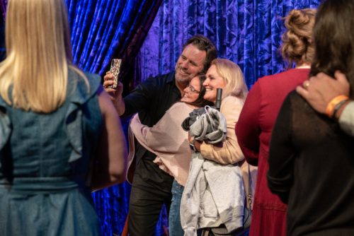 Charles Esten takes a selfie with caregivers. One hospital worker hugs Charles as the photo is taken.