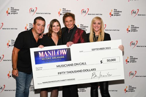 Barry Manilow with MOC Staff and Board with a large check representing a 50,000 dollar donation