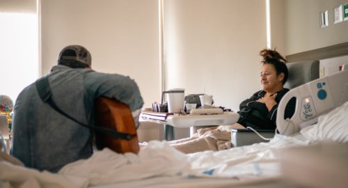 Photo of Michael Ray singing to a hospital patient