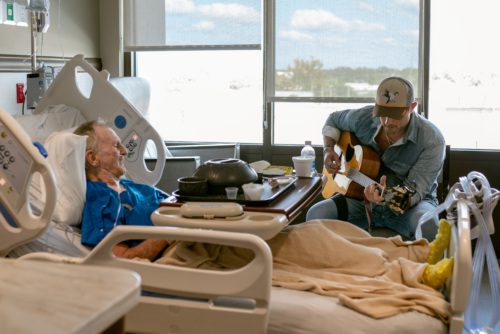 Photo of Michael Ray singing to a patient