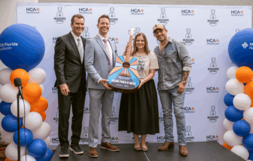 Photo of Michael Ray with MOC and hospital employees holding MOC guitar