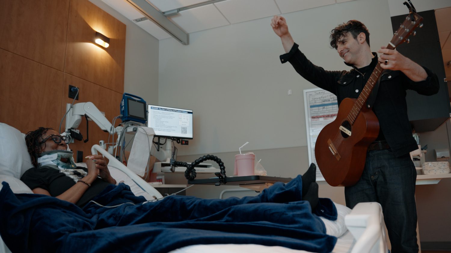 Adam Weiner performs at the bedside of a patient at Jefferson Moss-Magee Rehabilitation.