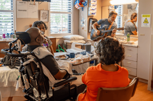 Photo of Charles Esten singing to hospital patients
