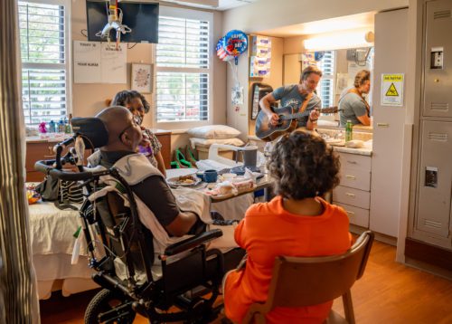Photo of Charles Esten singing to Veteran patient and family members