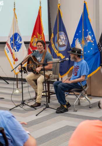 Photo of Charles Esten and Veteran patient singing