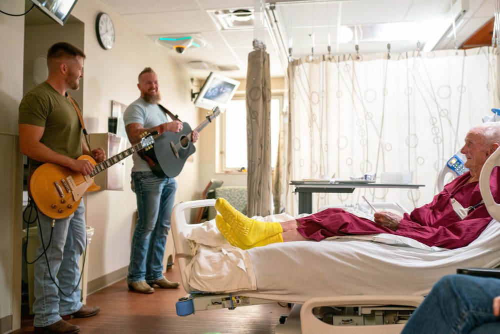Photo of volunteers playing music for hospital patient