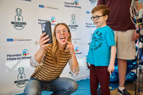 Photo Kristen Bell taking a picture with a hospital patient