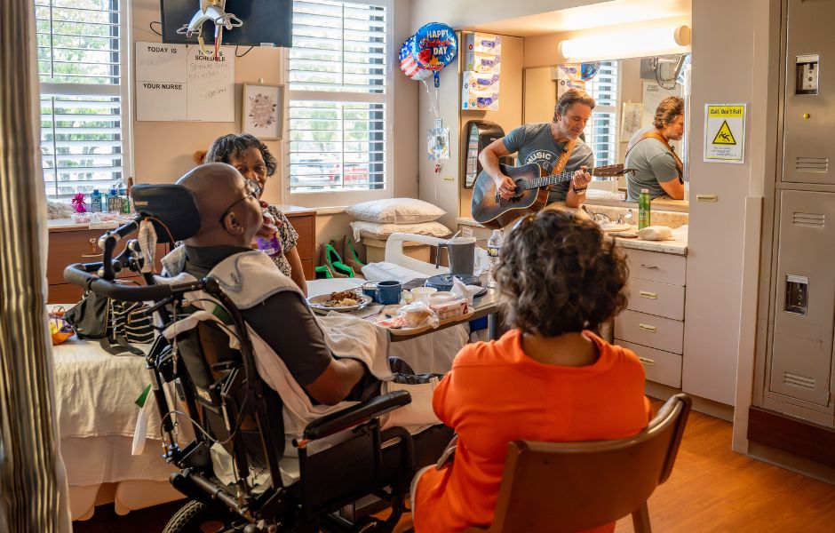 Photo of Charles Esten singing to hospital patients